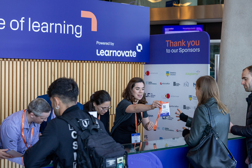 Attendees collect their badge from the registration desk at the Learnovation Summit.